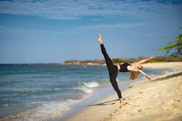 Chica joven rubia con medias negras haciendo poses de baile en la playa. Día de verano y feliz concepto de vacaciones . — Foto de Stock