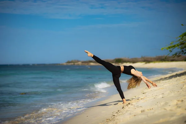 Chica joven rubia con medias negras haciendo poses de baile en la playa. Día de verano y feliz concepto de vacaciones . — Foto de Stock