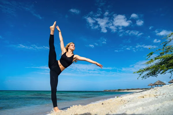 Chica joven rubia con medias negras haciendo poses de baile en la playa. Día de verano y feliz concepto de vacaciones . — Foto de Stock