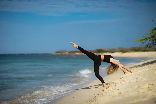 Chica joven rubia con medias negras haciendo poses de baile en la playa. Día de verano y feliz concepto de vacaciones . — Foto de Stock