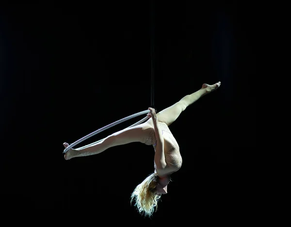 Acrobate aérien gracieux faisant sa performance avec un cerceau isolé sur noir — Photo