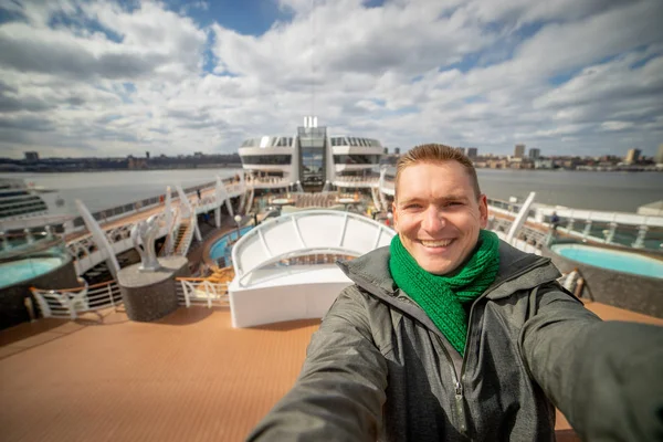 Joven hace selfie con gran crucero y la ciudad en el fondo — Foto de Stock