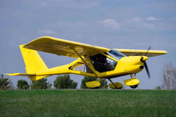 Küçük sarı charter uçak çıkarmak için yeşil bir alanda bekliyor — Stok fotoğraf