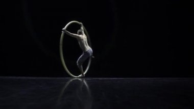 Cyr Wheel kas sirk sanatçısı zor hileler yavaş hareket yapıyor
