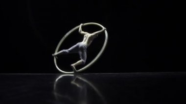Cyr Wheel kas sirk sanatçısı zor hileler yavaş hareket yapıyor