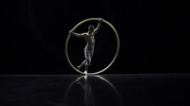 Cyr Wheel kas sirk sanatçısı zor hileler yavaş hareket yapıyor