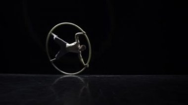 Siyah bir arka plan üzerinde tiyatro bir Cyr Wheel sirk sanatçı