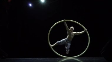 Cyr Wheel kas sirk sanatçısı zor hileler yavaş hareket yapıyor