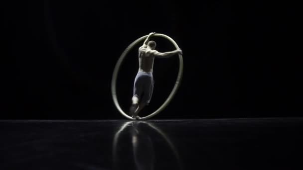 Circus performer artist in a Cyr Wheel in theatre on a black background — Stock Video