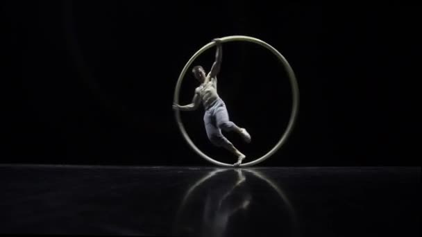 Circus performer artist in een Cyr Wheel in theater op een zwarte achtergrond — Stockvideo