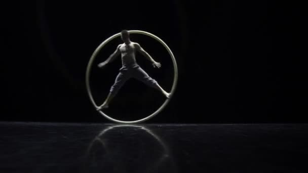 Artista intérprete de circo en una rueda de circo en el teatro sobre fondo negro — Vídeo de stock