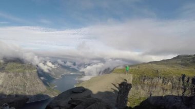 Genç adam atlamak kenarında Trolltunga. Norveç