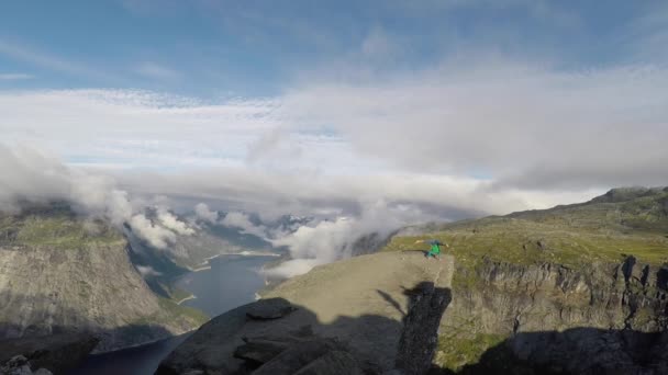 Turnster staande op zijn handen op de rand met fjord op achtergrond in de buurt van de Trolltunga. Noorwegen — Stockvideo