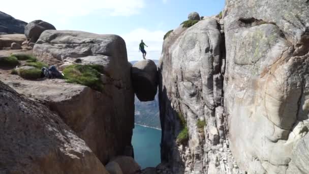 Man jumping over Kjeragbolten in Norway. Kjerag — Stock Video