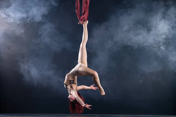 Kvinnlig atletisk, sexig och flexibel antenn cirkusartist med rödhårig dansar i luften på siden — Stockfoto