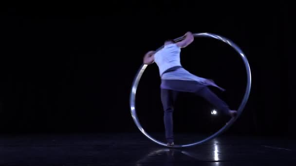 Cyr Wheel performer ukazuje triky na černém jevišti s kouřem — Stock video