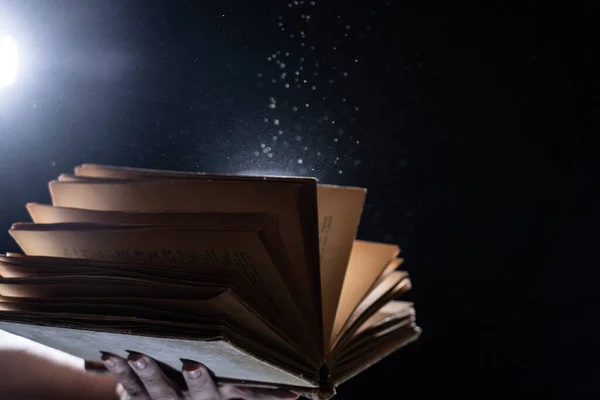 Vintage open Book Glows In The Darkness. Concept of self-education, knowledge and intellect