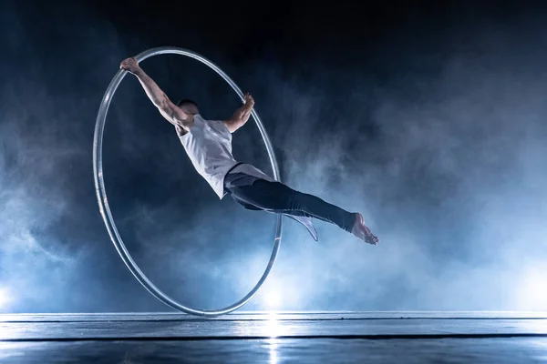 Cyr Wheel artista de circo sobre fondo ahumado y oscuro actuando en el escenario — Foto de Stock