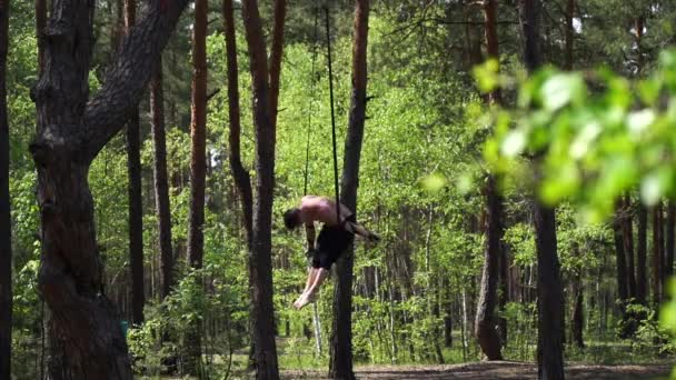 Ο άνθρωπος κάνει γυμναστική στο πράσινο πάρκο με TRX ή εναέρια λουριά. Υγιεινός τρόπος ζωής και ευεξία — Αρχείο Βίντεο
