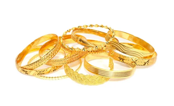 Bracciali in oro su sfondo bianco Foto Stock Royalty Free