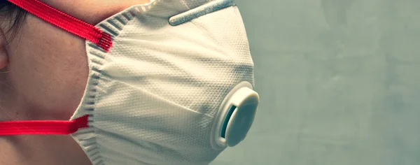 Koruyucu maske ya da solunum cihazı takan genç bir kadın. Koronavirüs önleyici pankart, virüs ve grip konsepti.