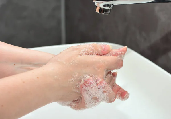 Genç bir kadın ellerini salgın sırasında hijyen kurallarına göre yıkar. Pankart karantina, koronavirüs önleyici ve el yıkama konsepti.