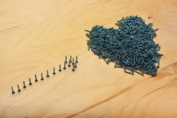 Kontrplak levhada metal vidalar var. Mobilya imalatı, donanım ve apartman onarım aletleri. Endüstriyel kaplama.