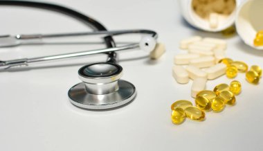 Haplı siyah steteskop, D vitamini ve E vitamini sağlık ve bağışıklık desteği konsepti..