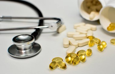 Haplı siyah steteskop, D vitamini ve E vitamini sağlık ve bağışıklık desteği konsepti..