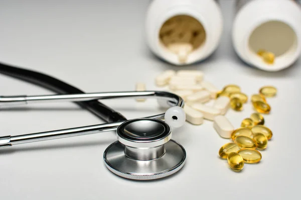 Haplı siyah steteskop, D vitamini ve E vitamini sağlık ve bağışıklık desteği konsepti..