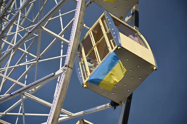 Kyiv, Ukrayna - 22 Ağustos 2020: Turistler Bayrak Günü ve Ukrayna 'nın Bağımsızlık Günü arifesinde Kyiv' deki Kontraktova Meydanı 'nda dönme dolaba biniyorlar.