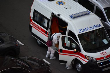 Kyiv, Ukrayna - 13 Ağustos 2020: Koruma kıyafetleri giyen ambulans Kyiv 'deki yüksek binalardan birinin bahçesine çağrıldı.