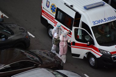 Kyiv, Ukrayna - 13 Ağustos 2020: Koruma kıyafetleri giyen ambulans Kyiv 'deki yüksek binalardan birinin bahçesine çağrıldı.