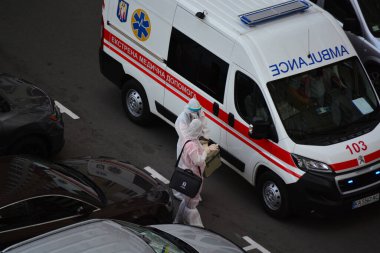 Kyiv, Ukrayna - 13 Ağustos 2020: Koruma kıyafetleri giyen ambulans Kyiv 'deki yüksek binalardan birinin bahçesine çağrıldı.
