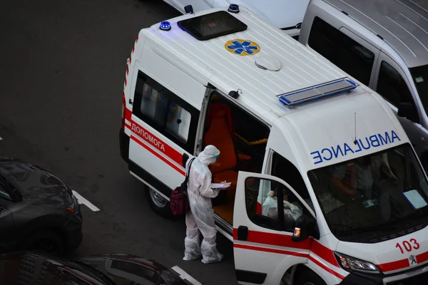 Kyiv, Ukrayna - 13 Ağustos 2020: Koruma kıyafetleri giyen ambulans Kyiv 'deki yüksek binalardan birinin bahçesine çağrıldı.
