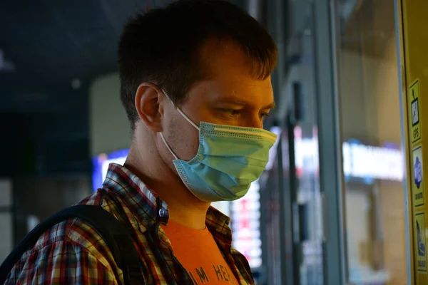 A passenger in the International Airport adheres to the restrictions associated with the COVID-19 pandemic: he wears masks and observes social distancing.