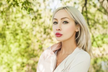 Genç kadın yüzü açık havada yeşil arka plan bırakır.