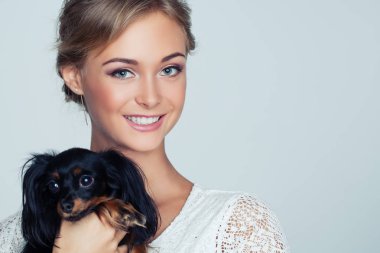 Kadın ve köpek yavrusu beyaz arka plan üzerinde gülümseyen genç portre portre