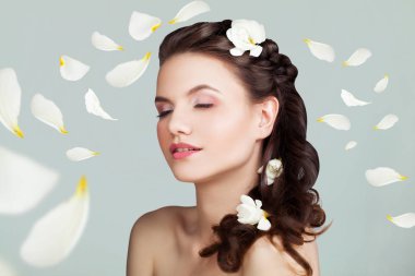 Sağlıklı olan kadın mükemmel saç modeli, makyaj ve beyaz gül yaprakları. Zevk ve saflık kavramı