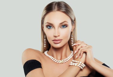 Makyaj, sarı saçlı, kolye ve küpe çekici genç kadın