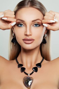 Mükemmel kadın yüzü. Makyaj, manikür, sarı saç ve takı olan kadın. Portre portre