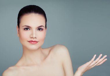Sağlıklı kadın modeli boş kopya alanı üzerinde mavi arka plan üzerine açık el ile. Plastik cerrahi, kozmetik, Cilt Bakımı ve sağlık kavramı. Ürün sunumu