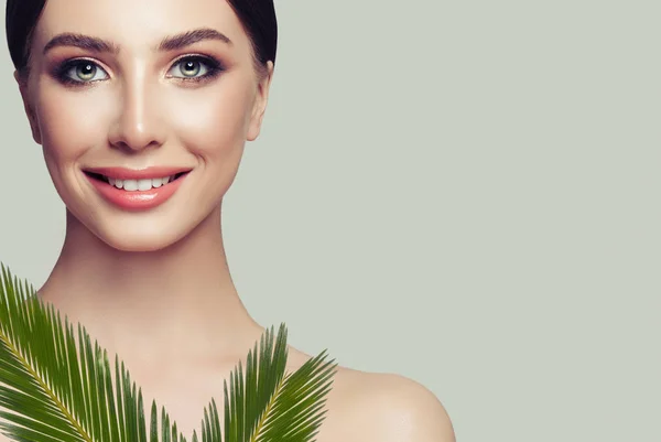 微笑的妇女水疗模型与完美健康的皮肤和绿色的叶子在灰色的背景 面部护理 美容和水疗美容 — 图库照片
