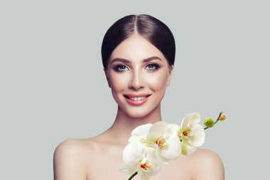 Sağlıklı cilt, sevimli gülümseme ve orkide çiçekleri ile mutlu kadın spa modeli. Yüz tedavi, kozmetik, güzellik salonları, Cilt Bakımı ve spa
