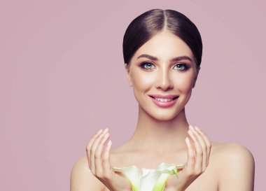 Makyaj ve Pastel pembe bir arka plan üzerinde çiçekler olan güzel kadın