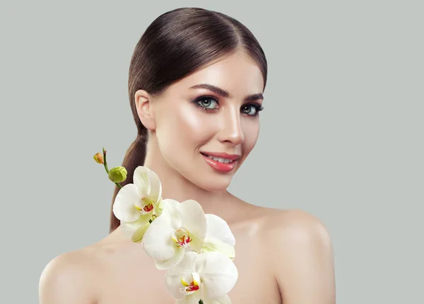 水疗美容 年轻完美的女性脸与健康的皮肤和兰花花 面部护理 水疗和美容院背景 — 图库照片