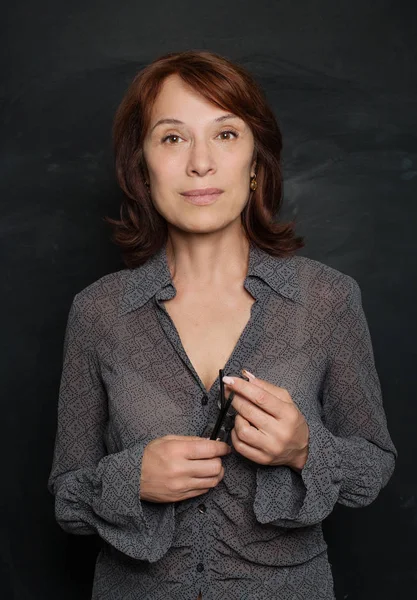 Akıllı iş kadını Olgun gülümseyen ve gözlük tutan