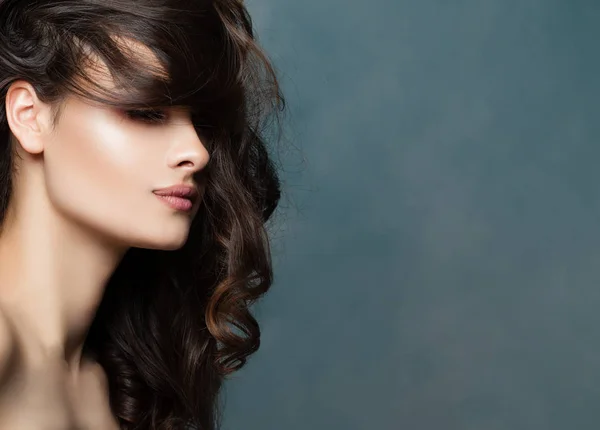 Beauty woman face, profile. Female model brunette with wavy hairstyle on background with copy space