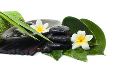 Spa tropikal yaprak ve çiçek ve siyah taşlar sağlıklı tedavi için