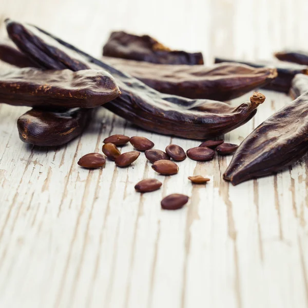 Carob Friska Organiska Söta Carob Pods Och Frön Vit Trä — Stockfoto